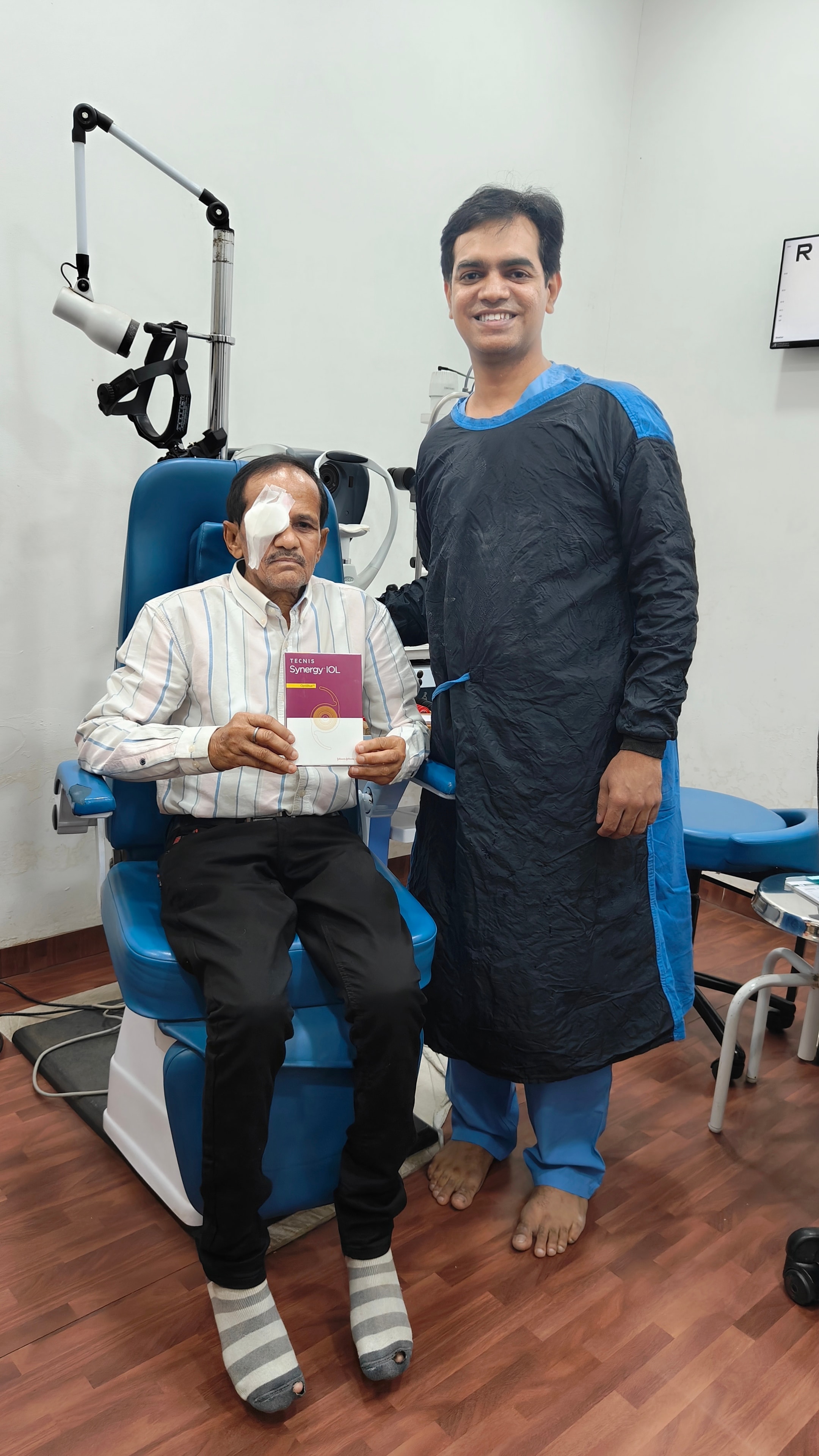 Happy cataract patient with Dr. Vishwakarma holding premium IOL lens